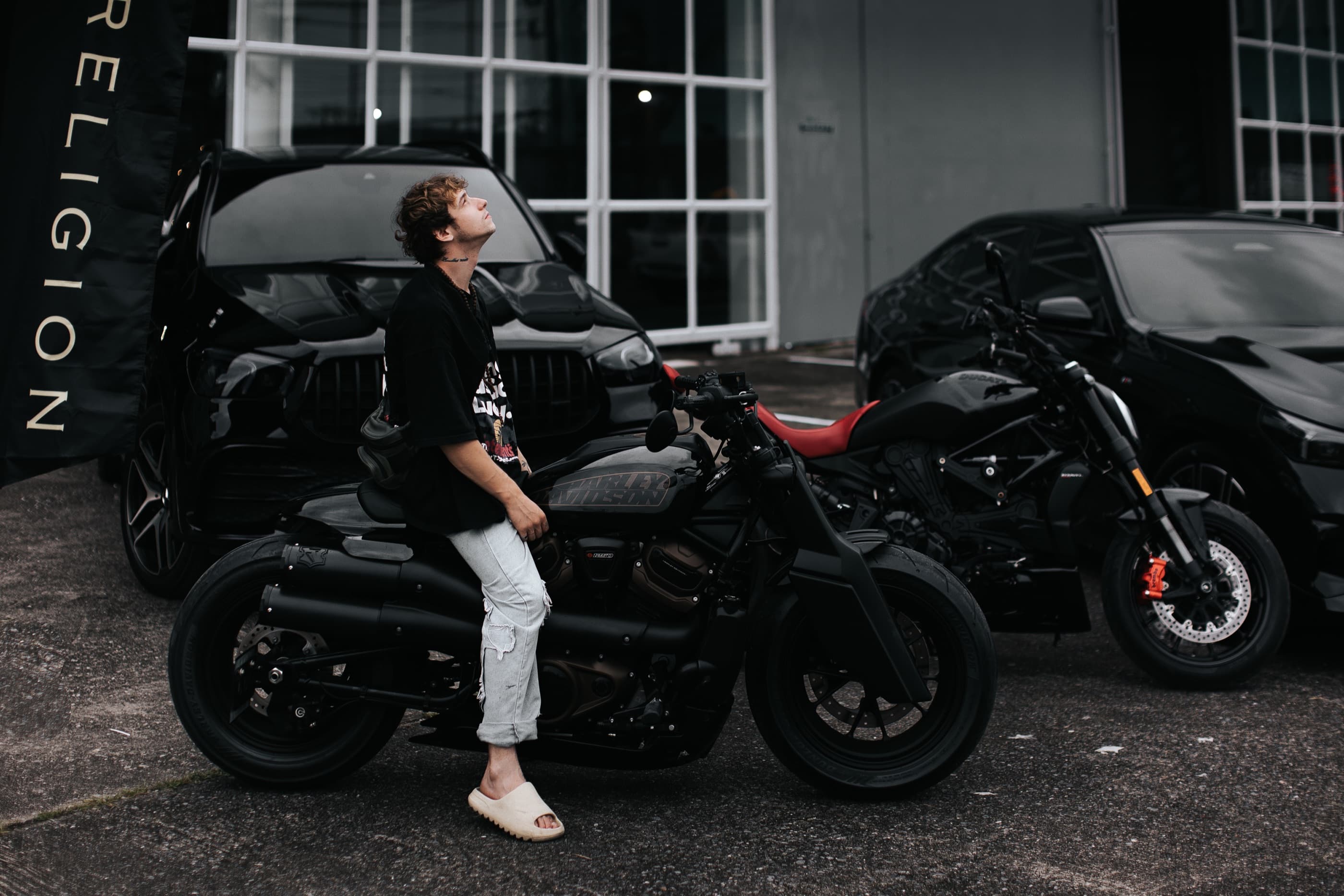 Райдер на Harley-Davidson Sportster S в Religion Rent, позади Ducati XDiavel и внедорожники